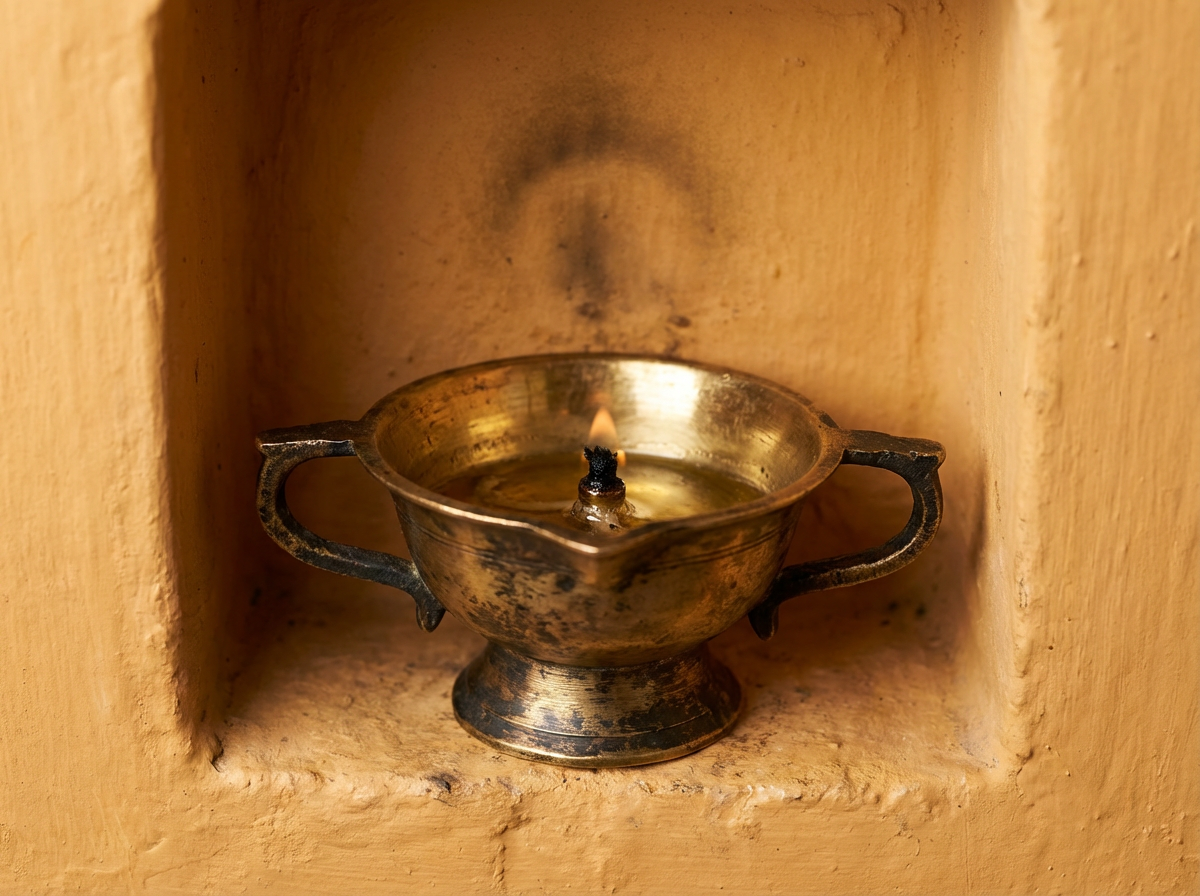 A brass diya, lit